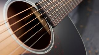 Close up of the strings on an acoustic guitar