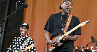 Buddy Guy and son Greg perform onstage together, with Greg taking a solo on his Telecaster and Buddy looking on with pride &ndash; he wears his trademark polka-dotted shirt.
