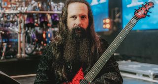 John Petrucci of Dream Theater is pictured onstage with his red signature Ernie Ball Music Man guitar