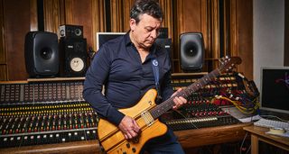 James Dean Bradfield of the Manic Street Preachers pictured in the studio where he showed guitarist his Eastman and Gordon Smith guitars. He wears a dark blue shirt, studio hardware occupies the background.