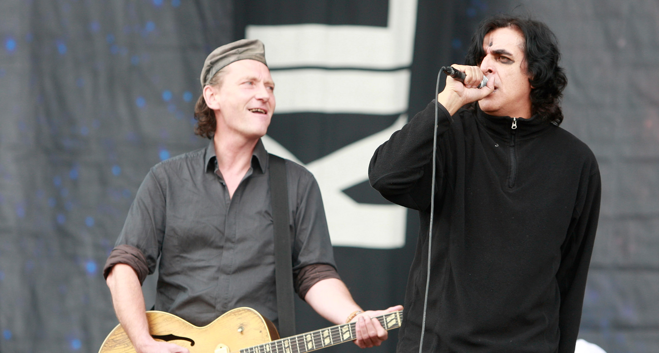 Killing Joke perform at 2009's Sonisphere at Knebworth, England. Geordie Walker [right] wears his trademark hat and plays his ES-295. Jaz Coleman wears all black and sings into the mic.