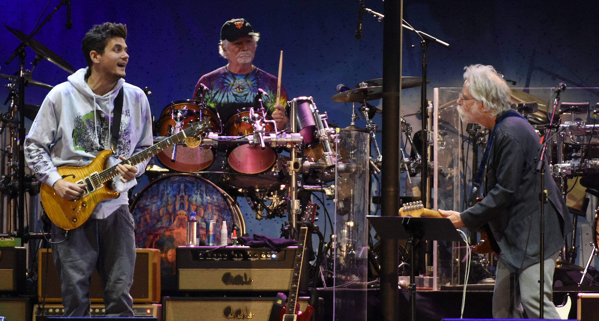 John Mayer wears a grey hoodie and plays a PRS as he james with Bob Weir [Left] during a Dead and Company show.