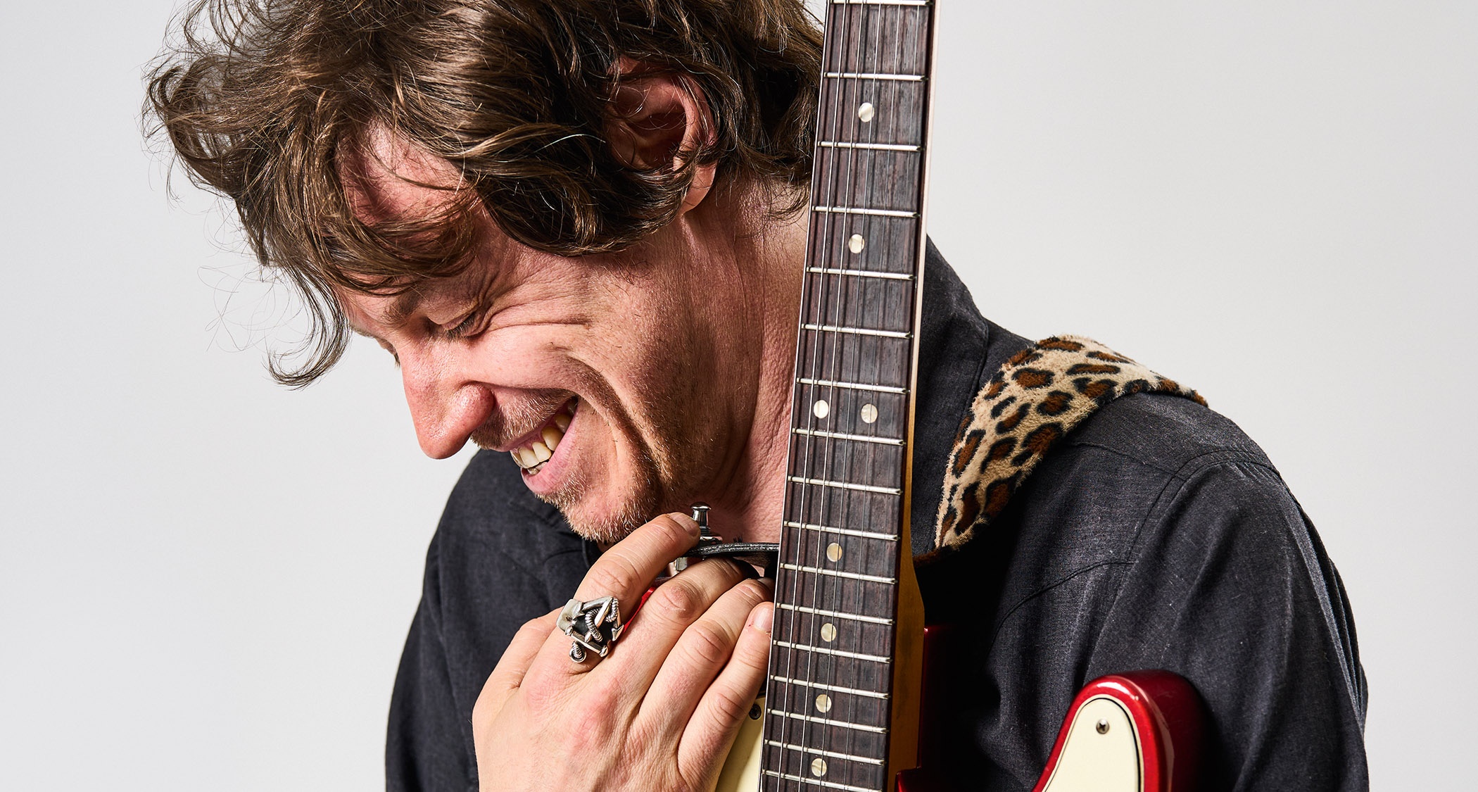 James Walbourne smiles as he holds his red Telecaster close.