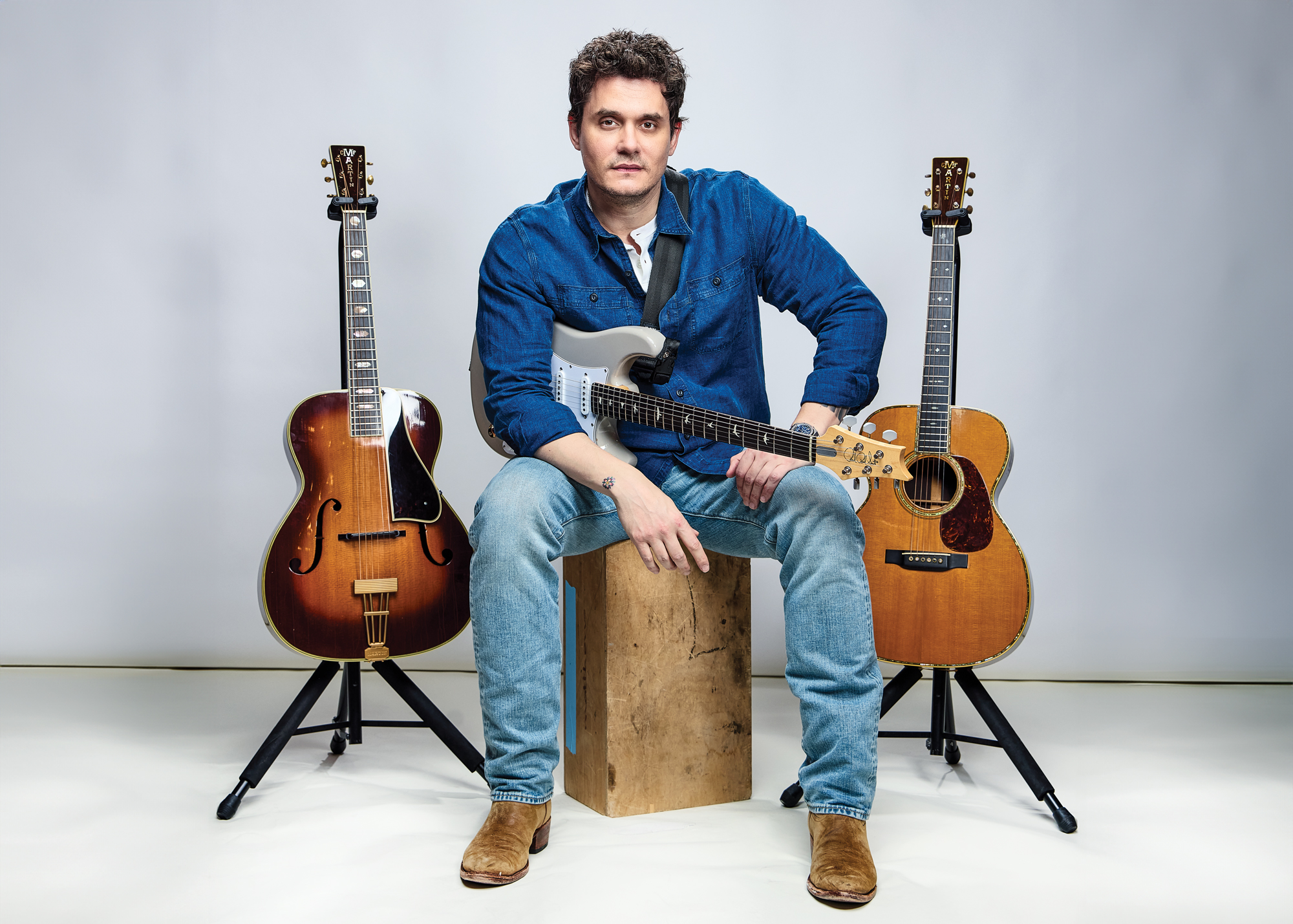 John Mayer poses with his electric and acoustic guitars