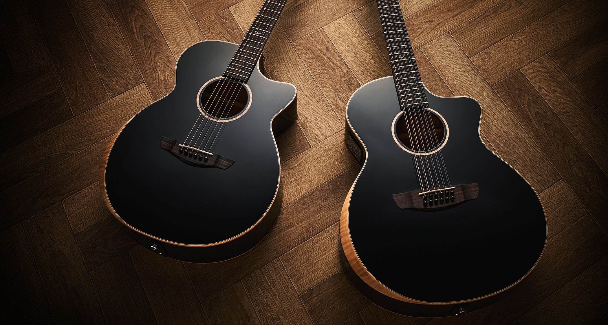 Faith Eclipse Venus E/Cutaway & Neptune E/Cutaway 12-String: two black-top acoustics sit on a parquet wood floor