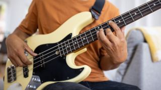 man playing bass guitar at home