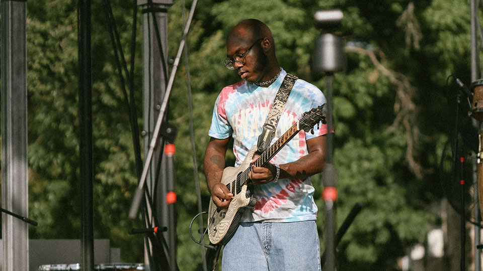 Justus West playing guitar onstage
