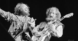 Ian Anderson [left] has a maniacal look on his face as Martin Barre takes a solo onstage. This black-and-white live shot of Jethro Tull was taken in 1982 at London's Wembley Arena.