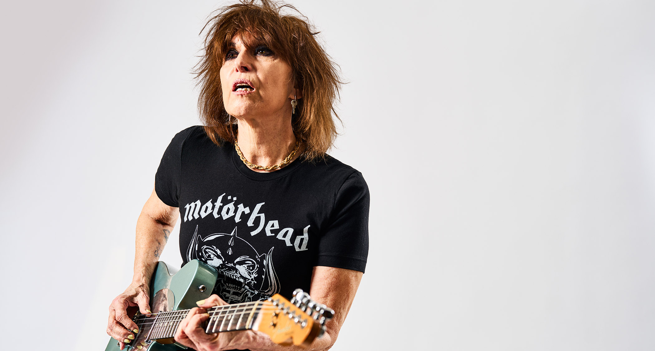 Chrissie Hynde of the Pretenders photographed in a Mot&ouml;rhead T-shirt. Her Ice Blue signature Telecaster is her weapon of choice.
