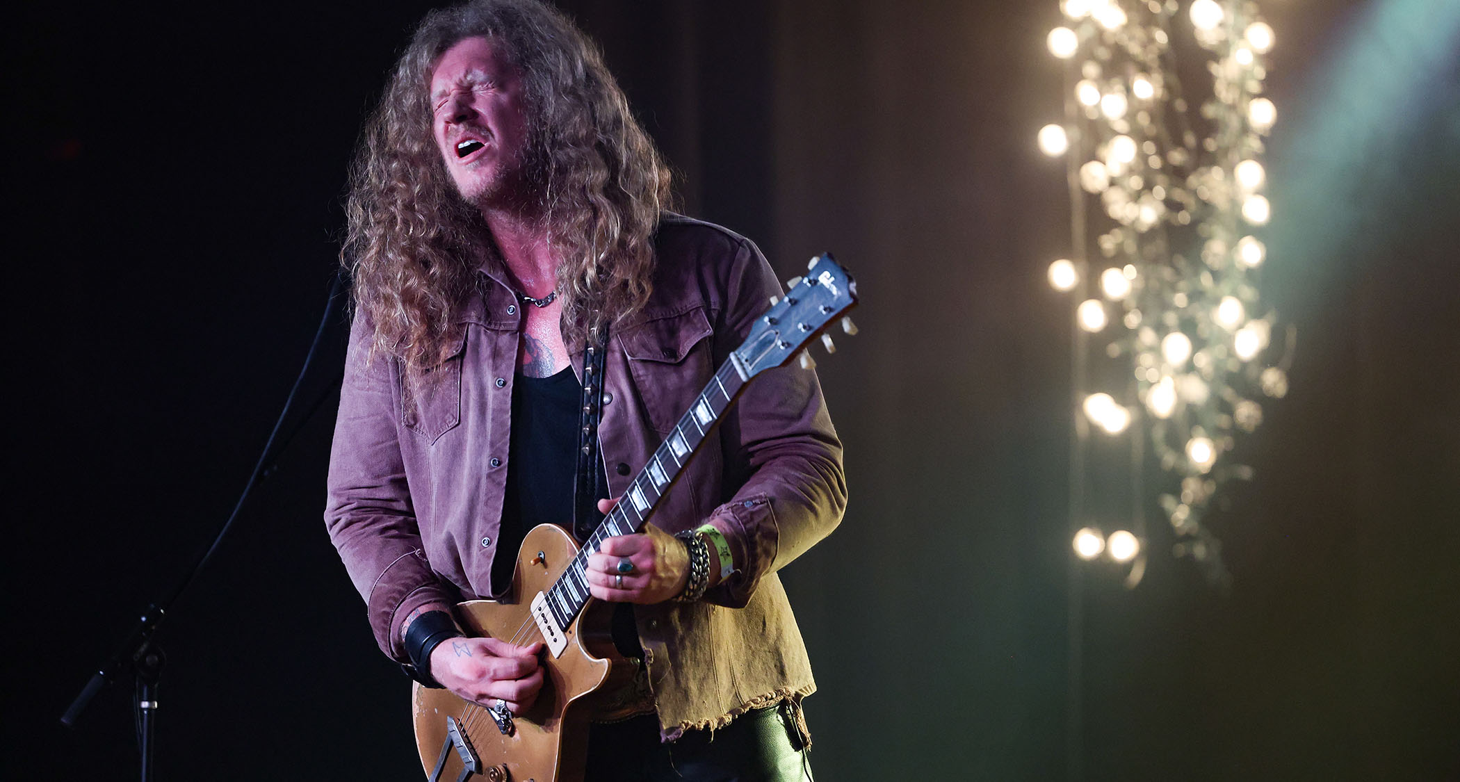 Jared James Nichols plays his gold-top Les Paul onstage, fingerstyle as per his wont, and wears a pained expression as he pinches a note. 